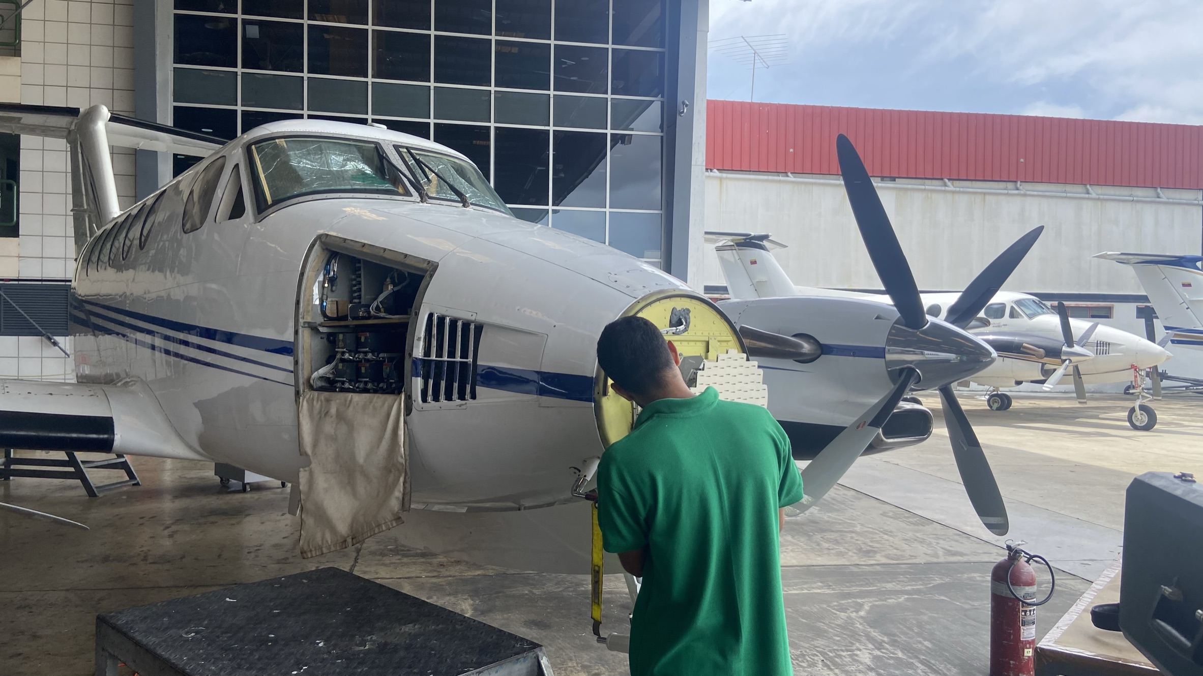 Technician performing a detailed avionics inspection.
