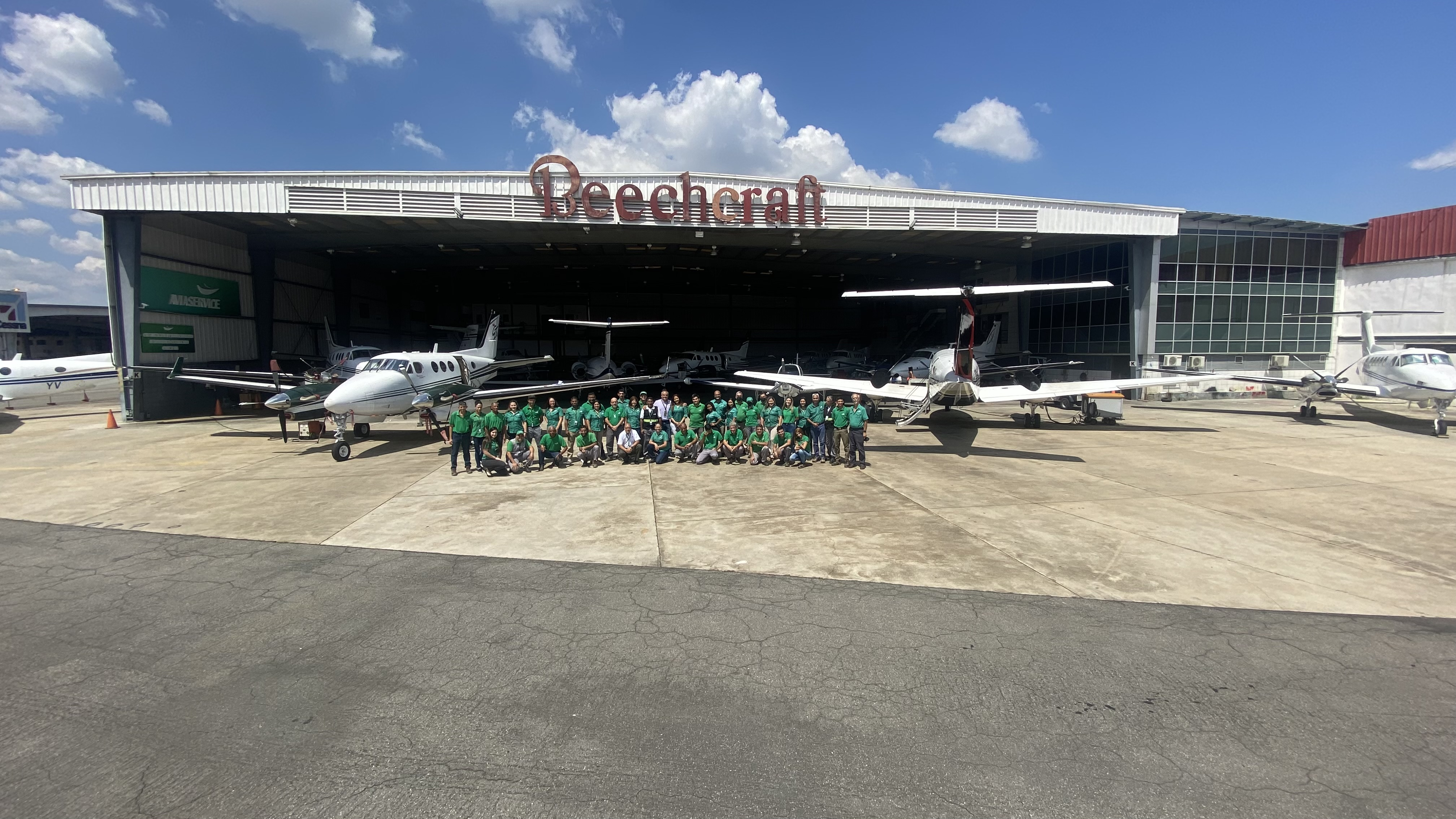 Aviaservice team gathered in front of a King Air aircraft at the Beechcraft hangar.